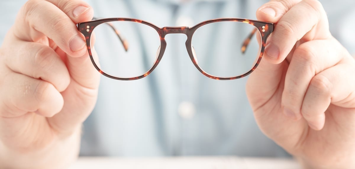 Hands Holding a Pair of Glasses