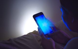 Woman Staring at Cell Phone Screen's Blue Light